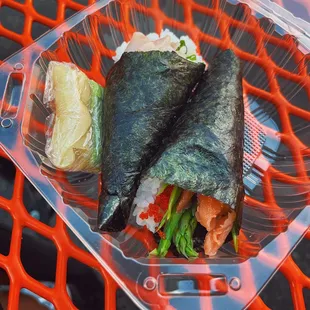 two pieces of sushi sitting in a plastic container