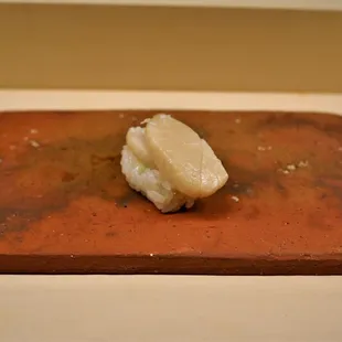 a piece of sushi on a cutting board