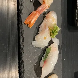 a variety of sushi on a black plate