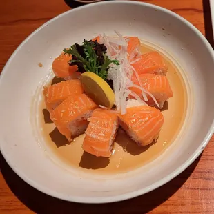 a plate of sushi with a lemon wedge