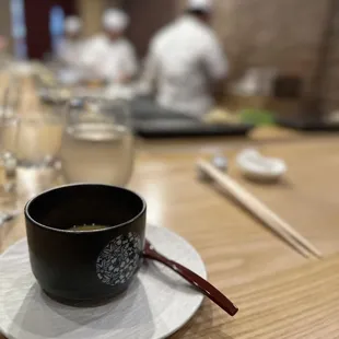 a bowl of sushi on a plate with chopsticks