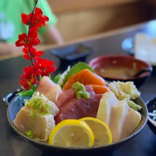 a plate of sushi with lemon slices