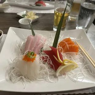 a plate of sushi with chopsticks