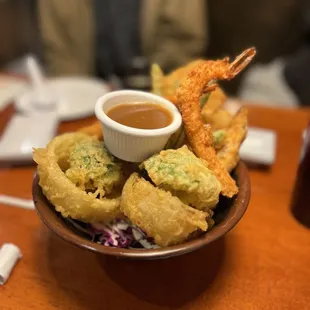 a plate of deep fried shrimp with dipping sauce