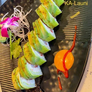 a variety of sushi on a black plate