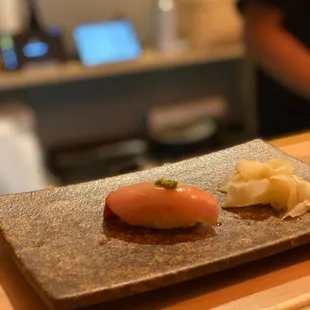 a plate of sushi and chopsticks