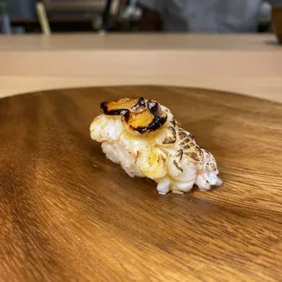 a piece of sushi on a wooden plate