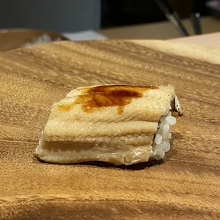 a piece of sushi on a cutting board