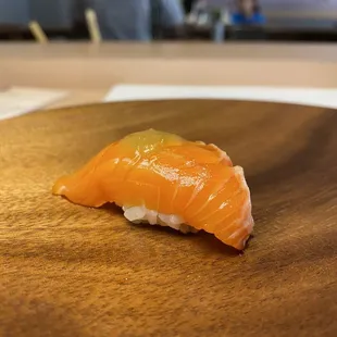 a piece of sushi on a wooden plate