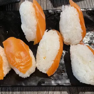 salmon and rice on a black plate