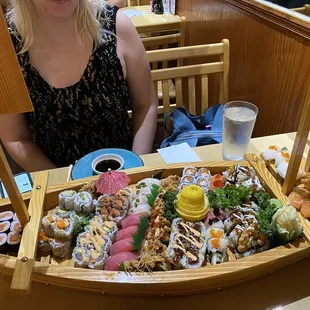 a woman sitting at a table with sushi