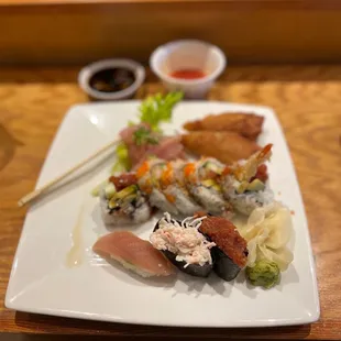 a plate of sushi with chopsticks