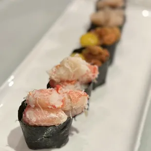 a row of sushi rolls on a white plate