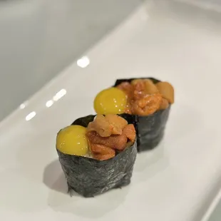 two pieces of sushi on a white plate