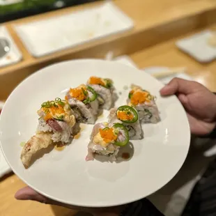 a person holding a plate of sushi