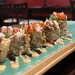 a long row of sushi on a green plate