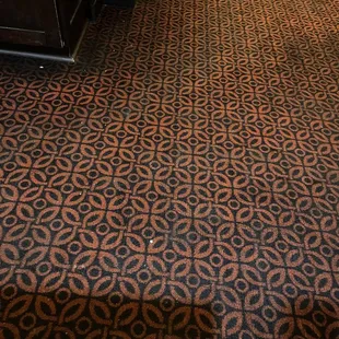 Filthy carpet as employees and manager walk past it like nothing is on the floor