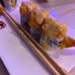 a plate of sushi and chopsticks