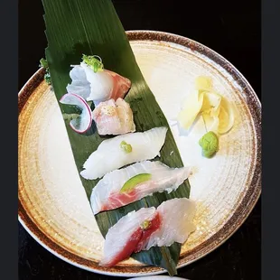 a plate of sushi on a banana leaf