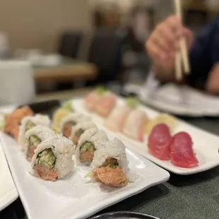 a plate of sushi with chopsticks