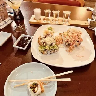 a plate of sushi and chopsticks