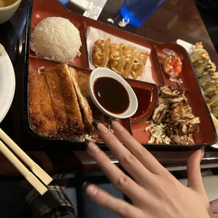 a person's hand reaching for a plate of food