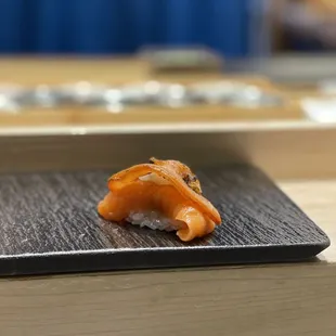 a sushi on a black plate