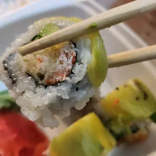 a plate of sushi with chopsticks