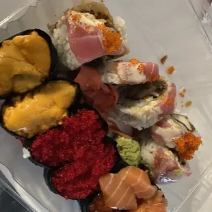 a variety of sushi in a plastic container