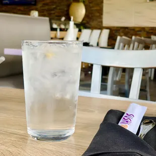 a glass of water and a napkin on a table