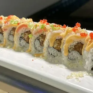 a long roll of sushi on a white plate