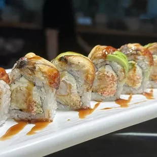 a plate of sushi rolls with sauce