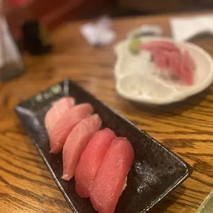 three pieces of sushi on a black plate