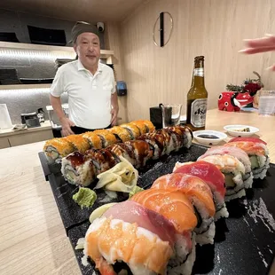 a man standing in front of a sushi platter