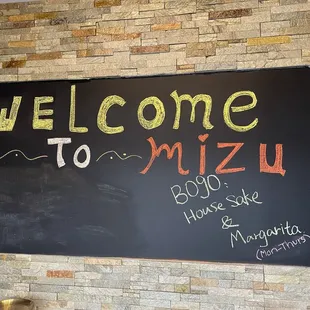 a welcome sign on a brick wall