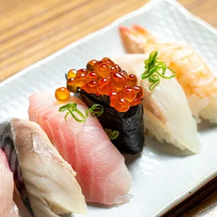 a variety of sushi on a white plate