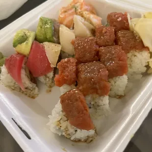 a container of sushi and vegetables