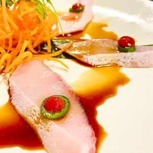 Yellowtail Heaven, thinly sliced &amp; served with spicy Ponzu, Serano chili, and Sriracha.