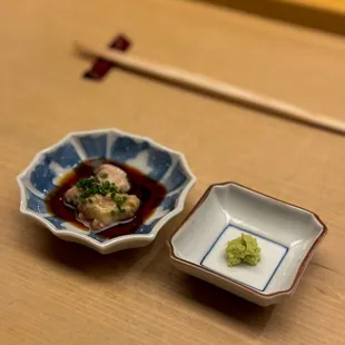 a small bowl of food and a small bowl of sauce