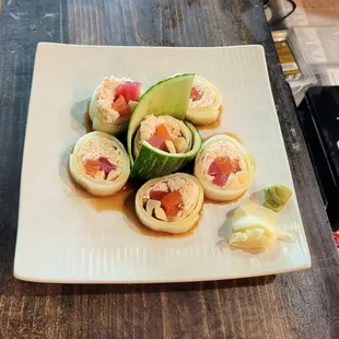 a plate of sushi and cucumbers