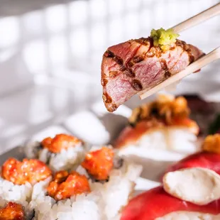 a close up of a sushi with chopsticks