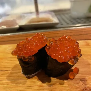 two pieces of sushi on a cutting board