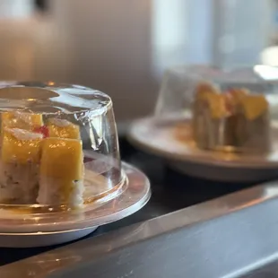 two plates of sushi on a conveyor belt