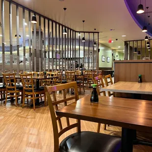 an empty restaurant with wooden tables and chairs