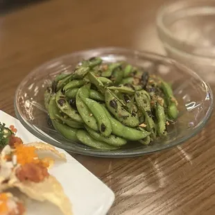 Spicy Edamame: Young soybeans sauteed with butter, toasted chilies, sea salt &amp; roasted garlic | $8.95