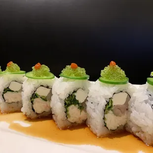 Our delicious Foothill roll contains imitation crab cream cheese yellowtail and cilantro, on top is green tobiko and jalapeño slices