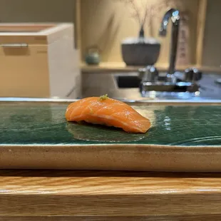 a piece of sushi on a green plate