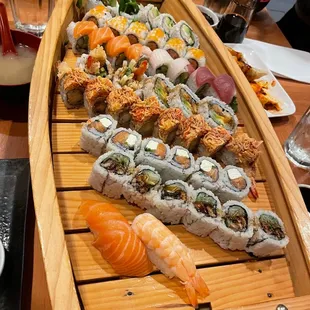 a long wooden boat filled with sushi