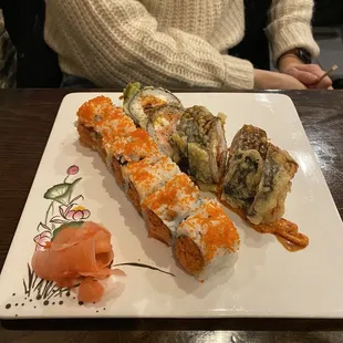 a person sitting at a table with a plate of sushi