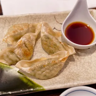 a plate of dumplings with dipping sauce